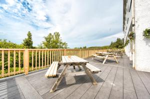 a deck with picnic tables on the side of a building at The Morar Hotel in Morar