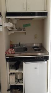 uma pequena cozinha com um lavatório e um fogão em Motel de l'anse em Port-Daniel