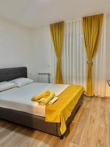 a bedroom with a bed with a yellow blanket on it at Skopje Apartments near central Bus Station JK APARTMENTS in Skopje