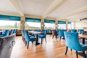 a dining room with blue chairs and tables at The Morar Hotel in Morar
