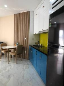 cocina con mesa y nevera negra en Luxury econest - west lake apartment with swimming pool & gym, en Hanói