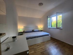 een kleine slaapkamer met een bed en een raam bij Holiday House Dunamis in Krivodol +49 foto's