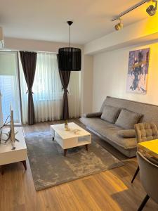 una sala de estar con un sofá y una mesa en Skopje Apartments near central Bus Station JK APARTMENTS, en Skopje