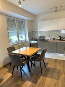 Una cocina con una mesa y sillas de madera. en Skopje Apartments near central Bus Station JK APARTMENTS, en Skopje