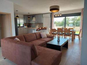 Una sala de estar con un sofá marrón y una mesa. en Villa Vallese Bale, en Bale