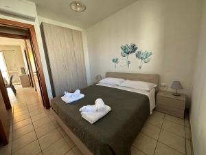 sypialnia z dużym łóżkiem z ręcznikami w obiekcie Appartamenti Le 2M w mieście San Pietro in Bevagna