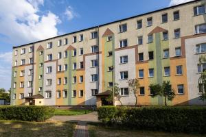 ein großes Gebäude mit vielen Fenstern in einem Park in der Unterkunft Apartament Plaza in Toruń