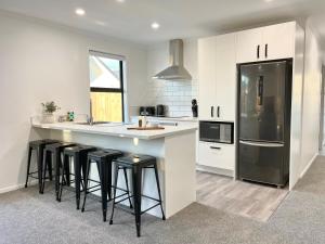 a kitchen with white cabinets and black appliances at Brand New & Ready for You! By KOSH BNB in Hamilton