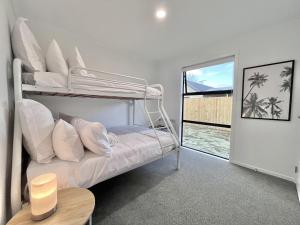 a bedroom with a bunk bed and a table at Brand New & Ready for You! By KOSH BNB in Hamilton