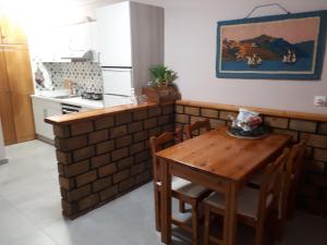 Garneli Apartments في كالامي: مطبخ صغير مع طاولة وكراسي خشبية
