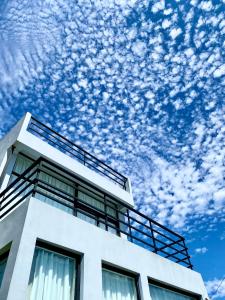 a white building with clouds in the sky at 墾丁花見小院Villa包棟民宿 in Eluan