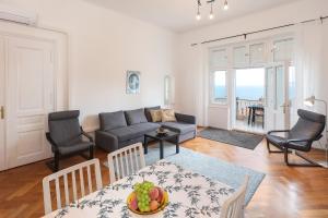 ein Wohnzimmer mit einem Sofa und einem Tisch in der Unterkunft Splendid View apartment Opatija in Opatija