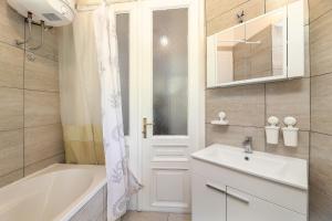 a bathroom with a tub and a sink and a mirror at Splendid View apartment Opatija in Opatija +54 photos