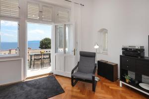 a living room with a chair and a balcony at Splendid View apartment Opatija in Opatija