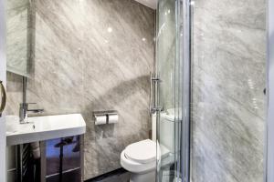 a bathroom with a shower and a toilet and a sink at The Morar Hotel in Morar