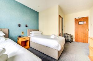 a hotel room with two beds and a door at The Morar Hotel in Morar