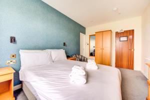 a bedroom with a bed with towels on it at The Morar Hotel in Morar