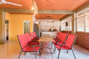 a dining room with a table and red chairs at Casa Vacacional Temixco in Temixco