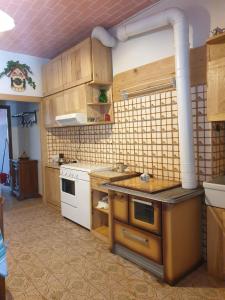 cocina con armarios de madera y estufa blanca en Casa Di Collina Nelle Langhe Typical country house, en Belvedere Langhe