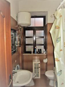 baño con lavabo y aseo y ventana en Casa Di Collina Nelle Langhe Typical country house, en Belvedere Langhe