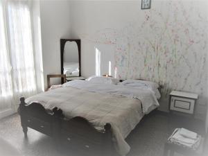 1 dormitorio con 1 cama grande y espejo en Casa Di Collina Nelle Langhe Typical country house, en Belvedere Langhe