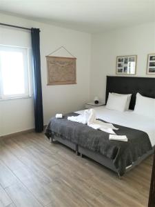 a bedroom with a large bed and a window at Casa Nikolina in Albufeira