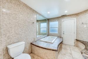 La salle de bains est pourvue de toilettes et d'un lavabo. dans l'établissement Fig Garden 4BR House W Pool, à Fresno