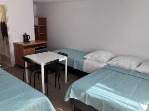 Pokój z 2 łóżkami, stołem i biurkiem w obiekcie Pokoje Na Złotych Wydmach w Dźwirzynie