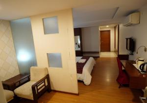 a hotel room with a bed and a desk at Hotel Sasya Pride in Kurnool