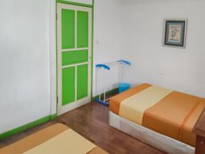 a bedroom with a bed and a room with a fan at Villa Anyelir Yustik Mitra RedDoorz in Selabintana
