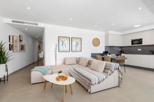 ein Wohnzimmer mit einem Sofa und einem Tisch in der Unterkunft Elegance Seaside Retreat in San Pedro del Pinatar