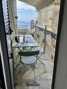 patio ze stołem i krzesłami na balkonie w obiekcie Village de Pozzo appart. 4 pers. w mieście Brando