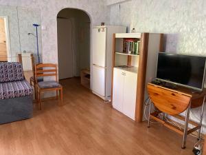 een woonkamer met een televisie en een koelkast bij Karja 5 Apartment in Narva-Jõesuu