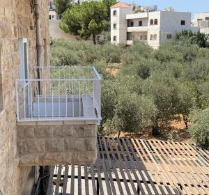 a balcony on the side of a building with trees at Lovely 3 Bedrooms Apartment at city center in Bayt Jālā