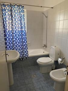 een badkamer met een toilet, een wastafel en een bad bij Lovely 3 Bedrooms Apartment at city center in Bayt Jālā