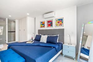 a bedroom with a blue bed and a mirror at Morgan Residences 508A in Cabo San Lucas +19 photos