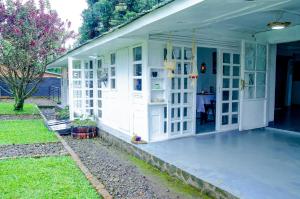 une terrasse couverte blanche d'une maison avec une table dans l'établissement MASHA ARTS STUDIO, à Ruhengeri