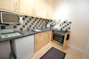 a small kitchen with a sink and a microwave at The Lobsterpot in Berwick-Upon-Tweed