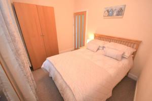 1 dormitorio con 1 cama con sábanas y almohadas blancas en The Lobsterpot en Berwick-Upon-Tweed