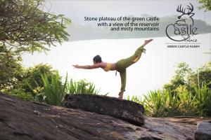 una mujer haciendo una pose de yoga en una roca en castle palace kandy, en Kandy