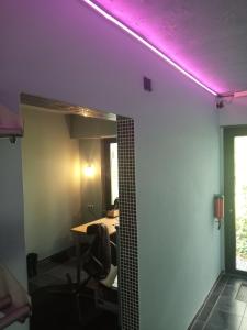 a room with a table and a purple light on the ceiling at Lijsterlaan 42 in Kapellen