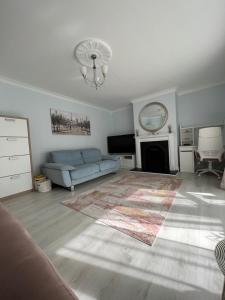 a living room with a blue couch and a fireplace at Adaline House Dublin in Dublin