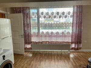 a kitchen with a large window with pink curtains at 2 bedrooms apartment in Ulaanbaatar