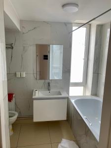 y baño con lavabo, bañera y aseo. en 2 bedrooms apartment en Ulán Bator