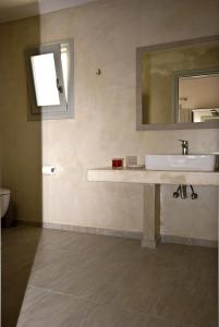 y baño con lavabo y espejo. en Alafouzos Studios & Apartments en Kamari