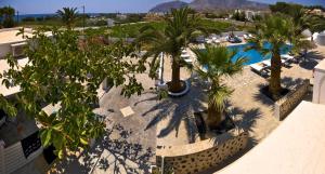 an aerial view of a resort with palm trees and a pool at Alafouzos Studios & Apartments in Kamari