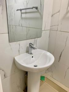 a white sink in a bathroom with a mirror at 2 bedrooms apartment in Ulaanbaatar