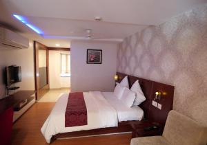 a hotel room with a bed and a couch at Hotel Sasya Pride in Kurnool +8 photos