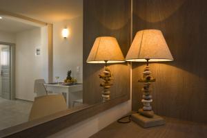 two lamps sitting next to a mirror in a room at Alafouzos Studios & Apartments in Kamari