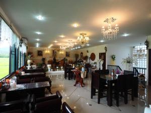 a restaurant with tables and chairs and chandeliers at Doi Samoe Dao Hostel in Nan